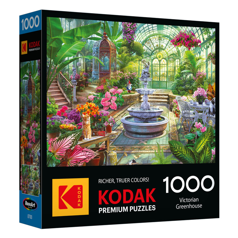 The ROSEART - KODAK PREMIUM - VICTORIAN GREENHOUSE 1000 piece jigsaw puzzle features artwork of a lush Victorian greenhouse with a central fountain and vibrant plants.
