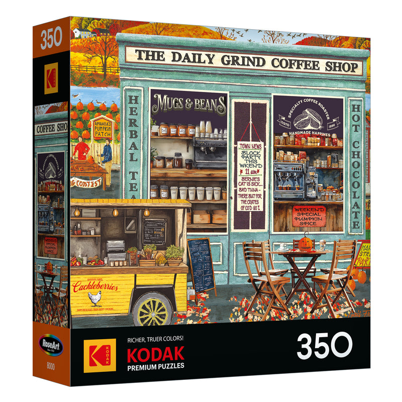 Front of ROSEART-KODAK PREMIUM-THE DAILY GRIND 350 piece jigsaw puzzle box featuring an illustrated coffee shop scene with outdoor seating, menu boards, and a food cart.