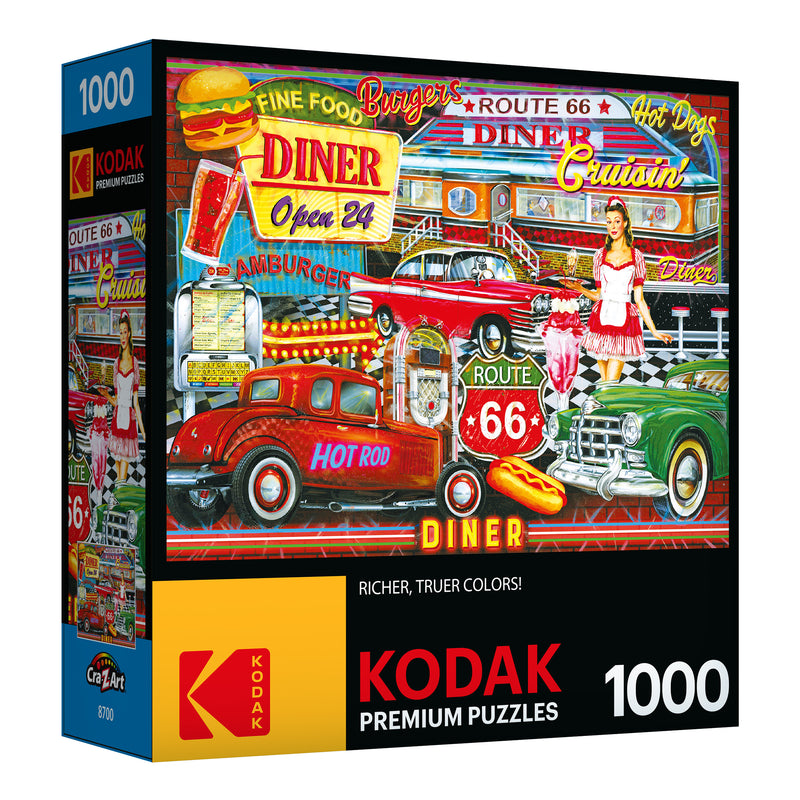Box of RoseArt - Kodak Premium - 50's Diner - 1000 Piece Jigsaw Puzzle containing a 1000-piece puzzle. The puzzle image features a vintage diner scene with classic cars and a waitress, advertising fine food, burgers, and hot dogs.