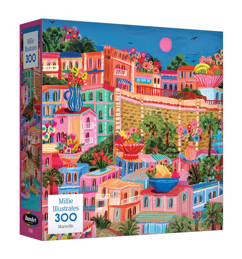 The ROSEART - MILLIE ILLUSTRATES - MARSEILLE 300-piece jigsaw puzzle displays a vibrant Mediterranean cityscape with pink, orange, and blue buildings under a pink sky filled with birds and lush greenery.