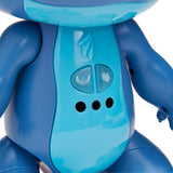 Close-up of a blue plastic toy with a smooth surface, two buttons featuring a cartoon face and a hand icon, and three circular speaker holes on its torso.