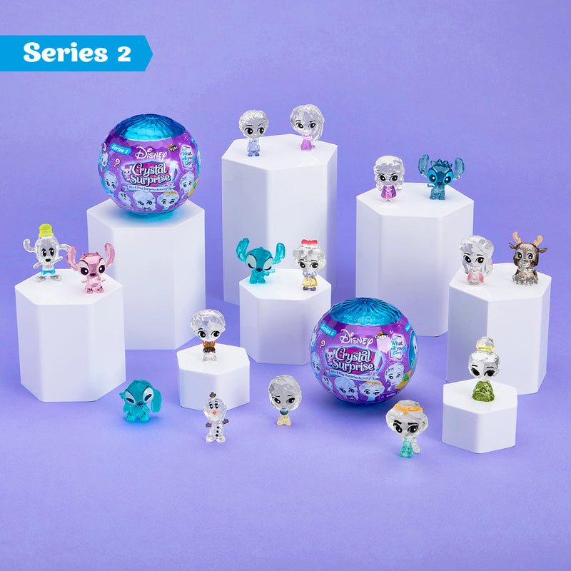 Disney Crystal Surprise Series 2 figurines and two unopened ball packages are displayed on white pedestals against a purple background.
