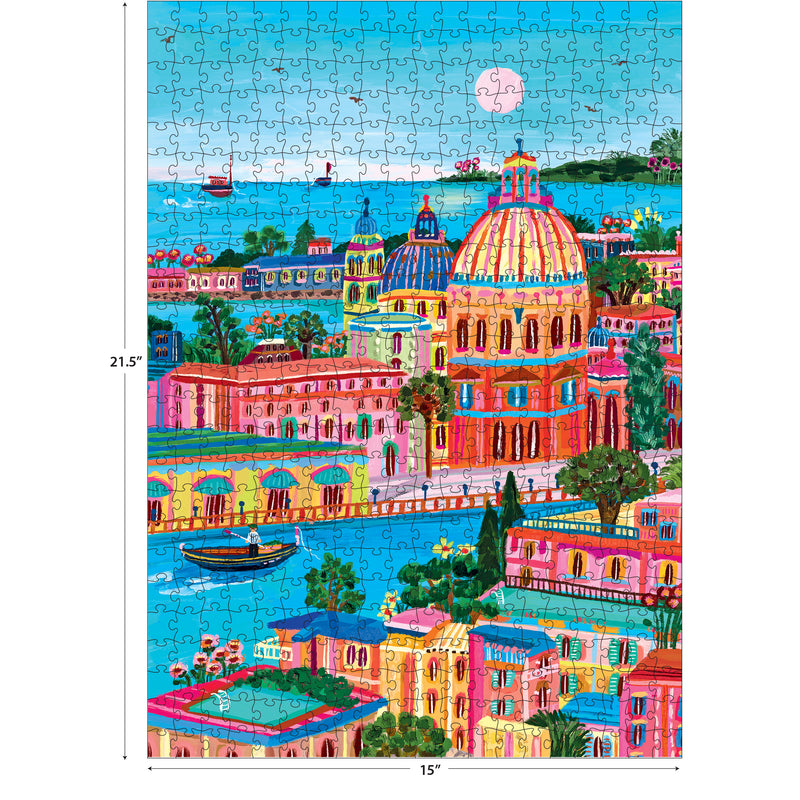 The ROSEART-KODAK CAMERA TO CANVAS-VENICE 500 piece jigsaw puzzle features a vibrant seaside Venice with domed buildings, boats, lush greenery, and a large pink sun or moon. Finished size: 21.5" x 15".