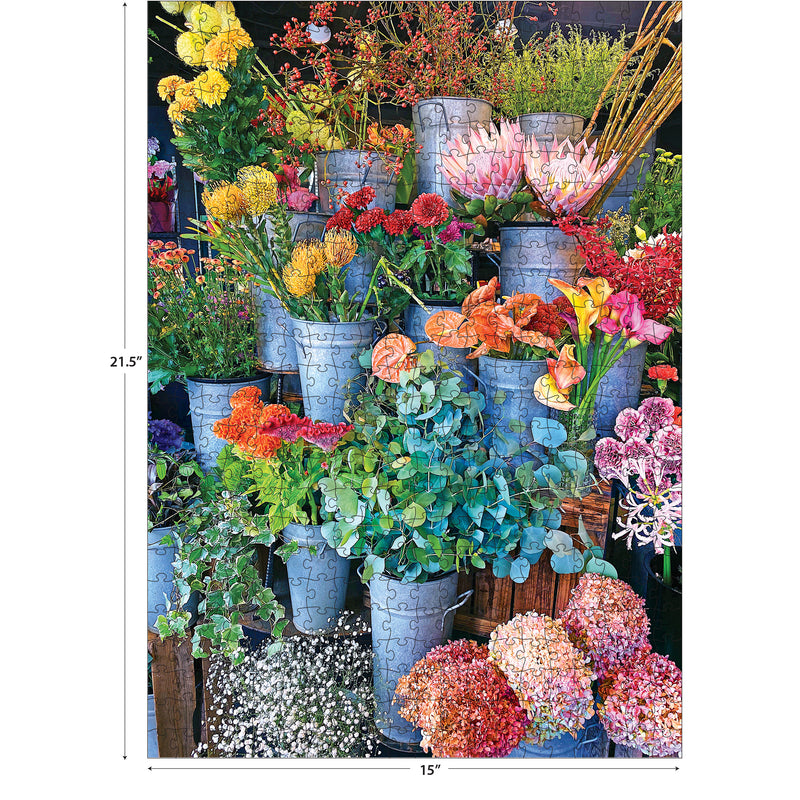 The ROSEART-KODAK CAMERA TO CANVAS-COLORFUL FLOWERS 500-piece jigsaw puzzle features vibrant flowers in metal buckets on wooden crates, measuring 21.5" x 15"—a picture-perfect challenge for puzzle lovers.