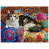 A fluffy cat relaxes on a colorful quilt with yarn balls, similar to the serene scene in the ROSEART KODAK PREMIUM KNITTING KITTEN 300-PIECE JIGSAW PUZZLE.
