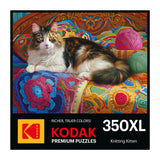 A cat lounges on a vibrant crocheted blanket with yarn balls around, featured on the ROSEART - KODAK PREMIUM - KNITTING KITTEN - 300 PIECE JIGSAW PUZZLE box.