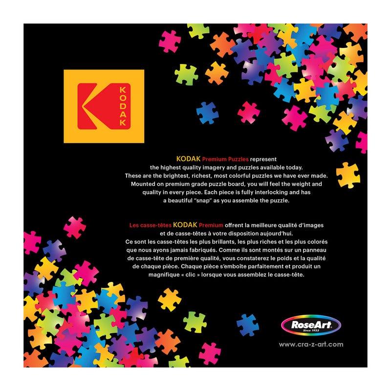 A colorful array of puzzle pieces surrounds a box featuring the Kodak logo. Text describes RoseArt-Kodak Premium-Club Pool-1000 Piece Jigsaw Puzzle as vivid, easy to handle, and with minimal dust. RoseArt branding is at the bottom.