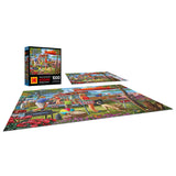 A completed RoseArt-Kodak Premium-Family Beach Vacation-1000 Piece Jigsaw Puzzle featuring a vibrant picnic scene with people, tables, and food. Two boxes of the same puzzle image are displayed alongside the finished puzzle.