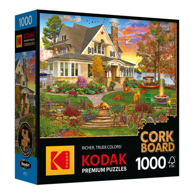The Cra-Z-Art - RoseArt - Kodak Cork - Lakeside Home 1000 Piece Jigsaw Puzzle box features a captivating illustration of a lakeside home encompassed by a flourishing garden, adorned with vivid flowers and trees. It prominently presents the Kodak and Cork Board logos.