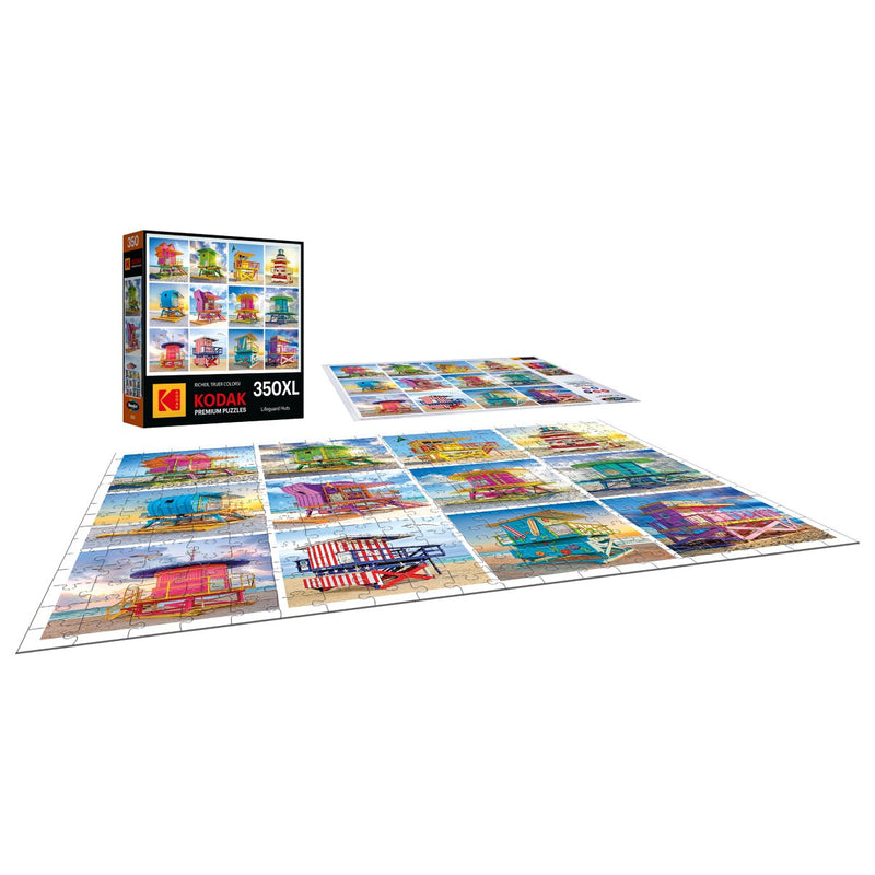 A RoseArt Kodak Premium puzzle is displayed with its vibrant lifeguard huts and seaside houses scene, partially assembled. The 350-piece jigsaw puzzle box stands upright next to the scattered pieces.
