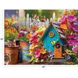 Puzzle image: A vibrant garden scene featuring flowers, a birdhouse, and songbirds nestled among the plants, with four cats lounging nearby as butterflies flit around. This 350-piece jigsaw puzzle from RoseArt's Kodak Premium - Songbirds 2 collection measures 18" x 24".