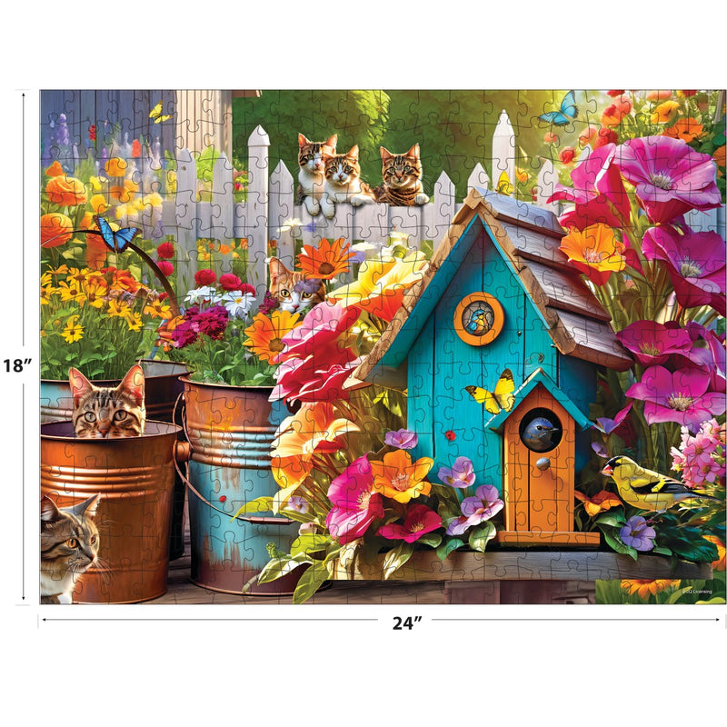 Puzzle image: A vibrant garden scene featuring flowers, a birdhouse, and songbirds nestled among the plants, with four cats lounging nearby as butterflies flit around. This 350-piece jigsaw puzzle from RoseArt's Kodak Premium - Songbirds 2 collection measures 18" x 24".