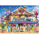 The 1000-piece ROSEART KODAK PREMIUM SURF SHACK puzzle captures a colorful surf shack adorned with surfboards, flags, and beach gear. The vibrant two-story building features decorations and umbrellas beneath flying seagulls, creating a picture-perfect scene.