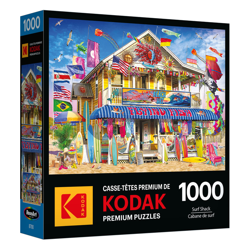 The ROSEART KODAK PREMIUM 1000-piece jigsaw puzzle box features a vibrant surf shack scene with surfboards, kites, and flags—ideal for enthusiasts.