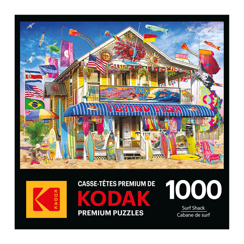 Puzzle box cover depicts a vibrant surf shack with surfboards, flags, and beach decorations. Text reads "ROSEART - KODAK PREMIUM - SURF SHACK - 1000 PIECE JIGSAW PUZZLE.