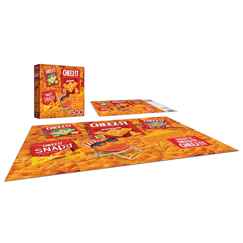 The ROSEART - SNACK ASSORTMENT - CHEEZ ITS 500-piece jigsaw puzzle showcases various Cheez-It packaging designs, completed on a flat surface with the box and lid beside it.