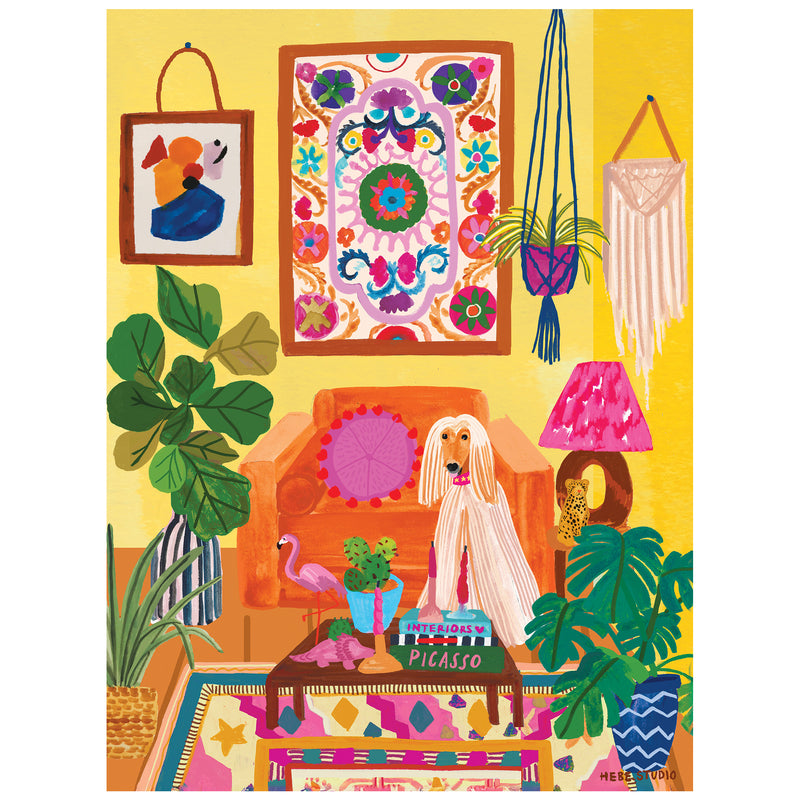 A colorful living room with patterned wall art, plants, a brown couch, a dog, macramé wall hanging, and the ROSEART - HEBE STUDIO - DOG'S LIFE - 300 PIECE JIGSAW PUZZLE beside the "PICASSO" book on the coffee table.