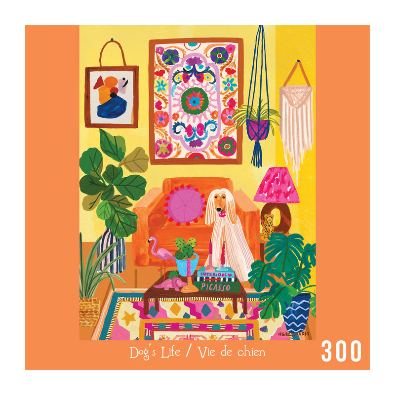 A dog sits on an orange armchair in a vibrant room with plants, art, and textiles. Beside it is a "Picasso" book. ROSEART - HEBE STUDIO - DOG'S LIFE 300 PIECE JIGSAW PUZZLE.