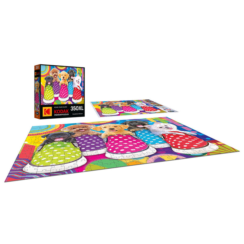 A completed RoseArt-Kodak Premium-Puppy Socks-350 Piece Jigsaw Puzzle showing colorful dogs in sweaters, with its box and pieces around.