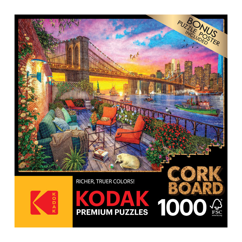 Box of RoseArt - Kodak Cork - Manhattan Balcony Sunset - 1000 Piece Jigsaw Puzzle showing a 1000-piece jigsaw puzzle with an image of a sunset cityscape including a bridge and outdoor seating area.