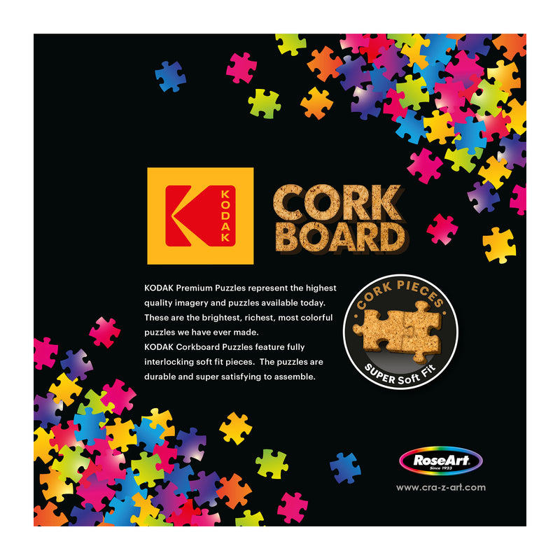 RoseArt - Kodak Cork - Manhattan Balcony Sunset - 1000 Piece Jigsaw Puzzle packaging featuring a multicolored puzzle piece design and details about the high quality and soft fit interlocking pieces. The brand RoseArt is also mentioned.