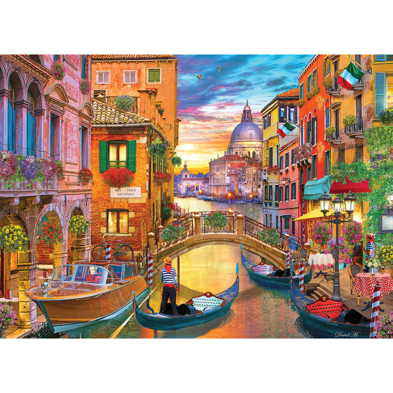 The ROSEART - KODAK PREMIUM - GRAND CANAL VENICE - 1000 PIECE JIGSAW PUZZLE captures the colorful spirit of Venice’s Grand Canal at sunset, with gondolas, vibrant buildings, a bridge, and outdoor dining. It's perfect for reliving a Kodak moment or enjoying as a delightful puzzle.