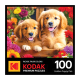 Box cover for the ROSEART - KODAK PREMIUM - GOLDEN PUPPY PALS 100-piece jigsaw puzzle features two golden puppies among colorful flowers.