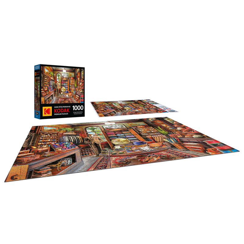 A completed 1000-piece Kodak Premium puzzle from RoseArt displays a detailed, colorful vintage haberdashery, with the classic design puzzle box visible in the background.