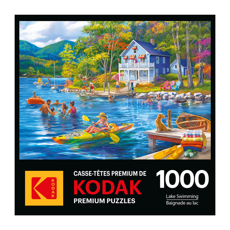 The ROSEART - KODAK PREMIUM - LAKE SWIMMING 1000 PIECE JIGSAW PUZZLE showcases a vibrant lake scene with people kayaking, a white house, and a dog. The box reads: "KODAK PREMIUM PUZZLES," "1000," and includes "Lake Swimming / Baignade au lac.