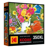 RoseArt's Kodak Premium 350-piece jigsaw puzzle features a spring bouquet with bright flowers, bluebirds, and chickadees near a birdhouse and watering can.