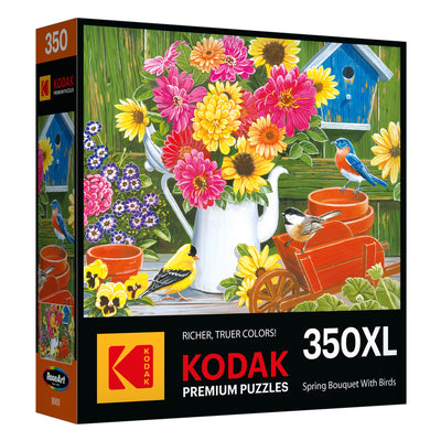 RoseArt's Kodak Premium 350-piece jigsaw puzzle features a spring bouquet with bright flowers, bluebirds, and chickadees near a birdhouse and watering can.