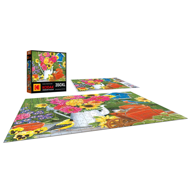 The "ROSEART - KODAK PREMIUM - SPRING BOUQUET WITH BIRDS" 350-piece jigsaw puzzle is partially completed on the box and showcases a vibrant floral design with gardening tools, ideal for flower enthusiasts.