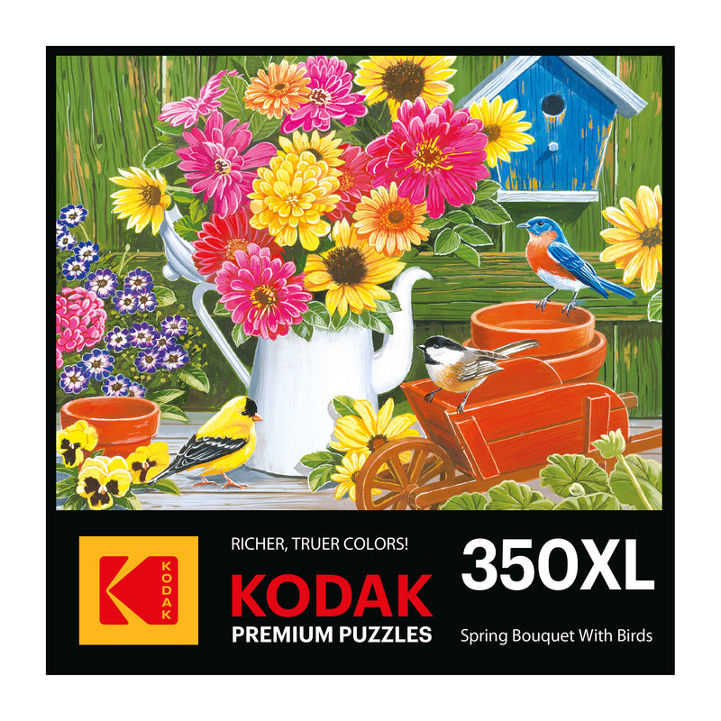 The puzzle box cover features a painted scene of vibrant flowers, a white watering can, and a red wheelbarrow with two birds. Text reads "Kodak Premium Puzzles, 350XL." It's perfect for enthusiasts as the ROSEART Kodak Premium Spring Bouquet with Birds 350-piece jigsaw puzzle.