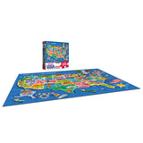 The ROSEART - UNITED STATES OF AMERICA MAP - 100 PIECE JIGSAW PUZZLE is assembled on a blue surface, with its puzzle box upright in the background.
