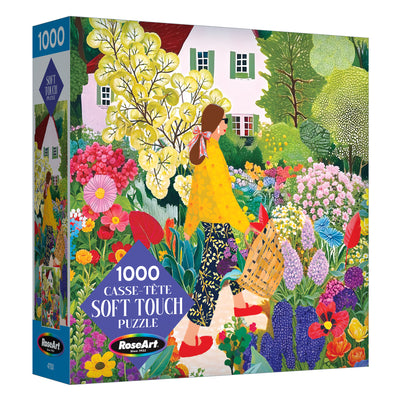The ROSEART Soft Touch Picking Flowers 1000 Piece Jigsaw Puzzle features an illustration of a woman picking flowers in a vibrant garden before a white house.