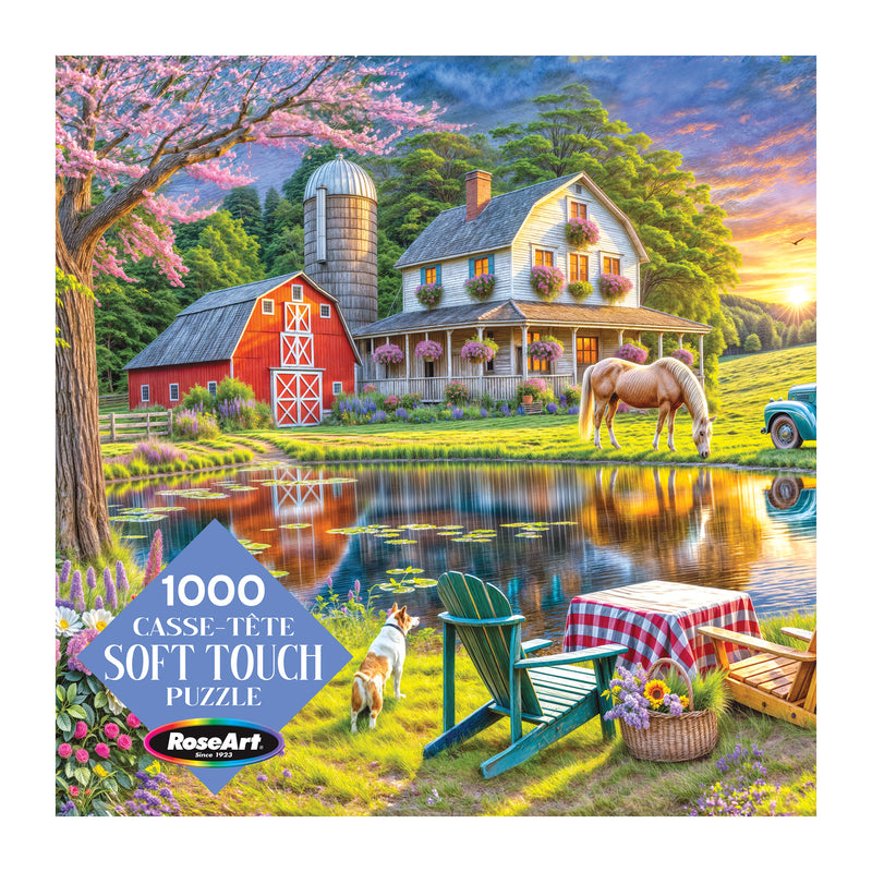 The ROSEART Soft Touch Backyard 1000 Piece Jigsaw Puzzle features a vibrant rural scene with a farmhouse, barn, horse, pond, picnic area, Adirondack chairs, and a dog on the colorful box.