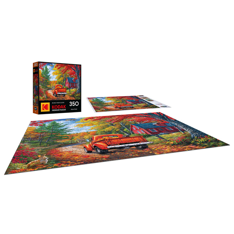 The ROSEART KODAK Premium Maine Road 350-piece jigsaw puzzle features an autumn scene with an orange vintage truck, red barn, and colorful trees—ideal for puzzle fans and Maine Road lovers. Shown assembled and in its box.