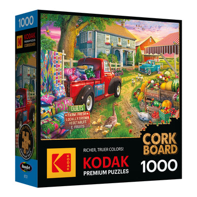 ROSEART KODAK CORK FARMHOUSE MARKET is a 1000-piece jigsaw puzzle featuring a colorful farmhouse market scene with a red vintage truck, quilts, produce, and house; branded KODAK CORK Premium Jigsaw Puzzle.