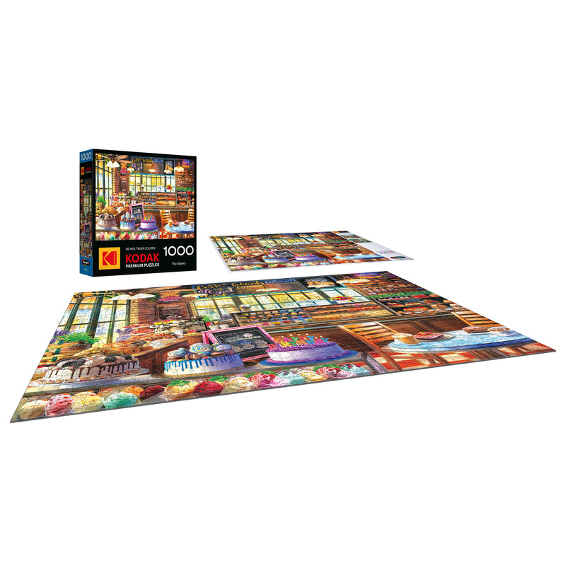 A completed ROSEART KODAK PREMIUM The Bakery 1000 piece jigsaw puzzle, displayed with its box and an extra view of the colorful bakery-themed puzzle.