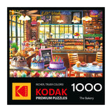 The ROSEART KODAK Premium "The Bakery" 1000-piece jigsaw puzzle features a vibrant bakery scene with cakes and pastries on its box.