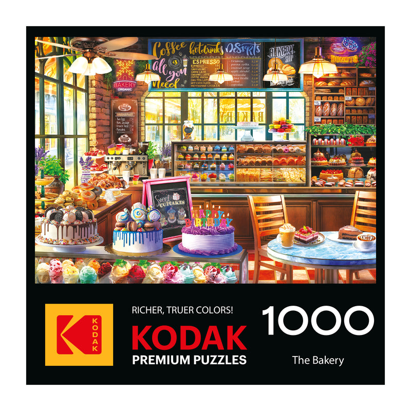 The ROSEART KODAK Premium "The Bakery" 1000-piece jigsaw puzzle features a vibrant bakery scene with cakes and pastries on its box.