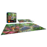 A completed ROSEART KODAK PREMIUM VICTORIAN GREENHOUSE 1000 piece jigsaw puzzle, showcasing a vibrant scene with flowers and a fountain, is displayed with the puzzle box and an unassembled section.