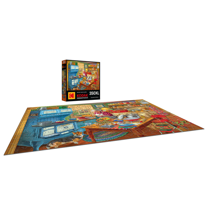 The 350-piece RoseArt KODAK Premium jigsaw puzzle, "Grandma's Kitchen," is completed on a flat surface with its box upright in the background, showcasing a colorful and intricate room filled with nostalgic charm.