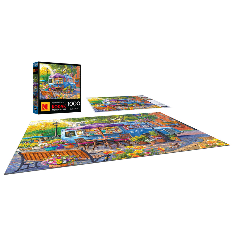 A completed ROSEART-KODAK PREMIUM CITY FOOD TRUCK 1000 piece jigsaw puzzle is displayed with its box and extra puzzle pieces.