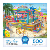 The ROSEART-BIGELOW ILLUSTRATIONS-SHAGGY'S SURF SHACK-500 PIECE JIGSAW PUZZLE box shows a vibrant scene of Shaggy's shop offering surfboards, beach gear, and snacks with people, umbrellas, and an ocean backdrop.