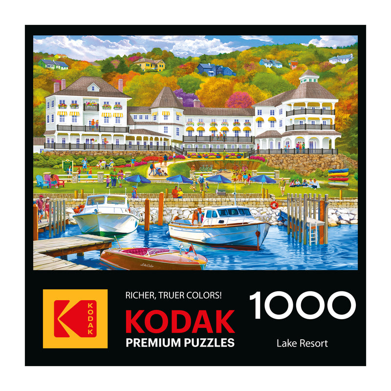 Illustration of a lively lake resort with people, boats, and a white hotel amid vibrant autumn trees; ROSEART-KODAK PREMIUM-LAKE RESORT 1000 piece jigsaw puzzle branding at the bottom.