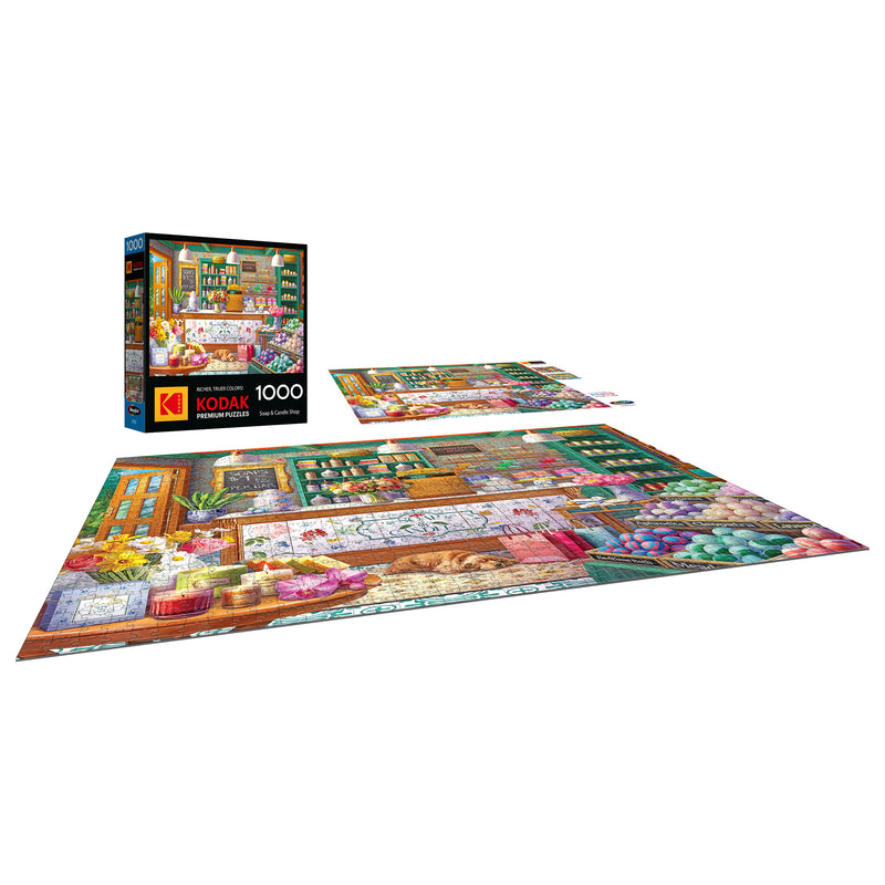 The ROSEART-KODAK PREMIUM-SOAP & CANDLE SHOP 1000 piece jigsaw puzzle displays a vivid shop scene, shown both completed and in progress, with the Kodak-branded box visible in the background.