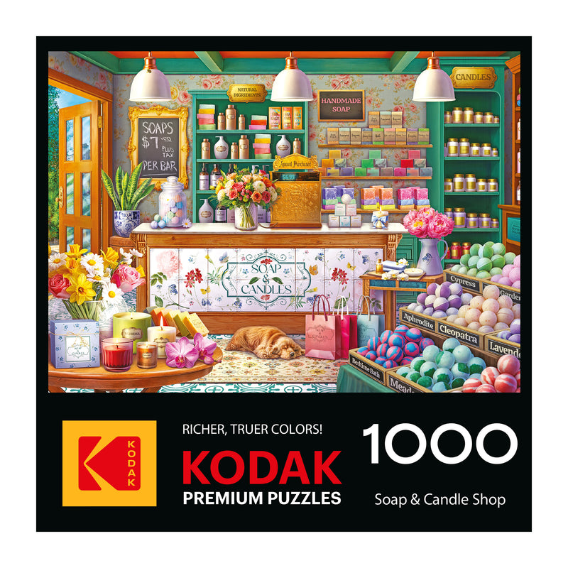 The ROSEART-KODAK PREMIUM-SOAP & CANDLE SHOP 1000 piece jigsaw puzzle features an illustrated shop scene with vibrant soaps, flowers, and candles throughout the store.