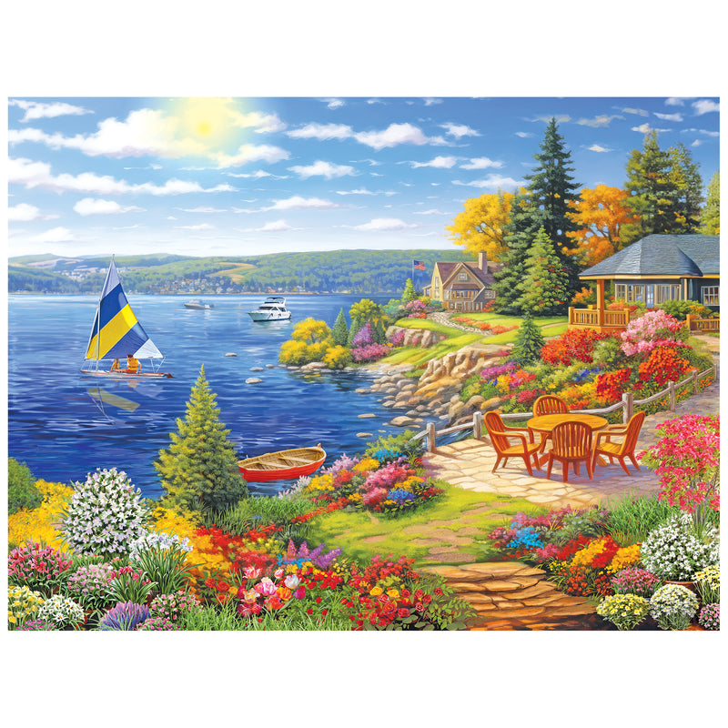 Experience the beauty of lakeshore living with the ROSEART-KODAK PREMIUM 350 piece jigsaw puzzle, featuring a sailboat, dock, vibrant flowers, patio chairs, and cozy houses amid trees under a bright, cloud-dappled sky.