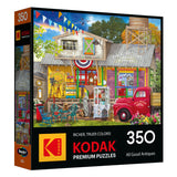 The ROSEART-KODAK PREMIUM All Good Antiques 350-piece jigsaw puzzle features a vibrant antique shop scene brimming with unique collectibles and a classic red truck out front.